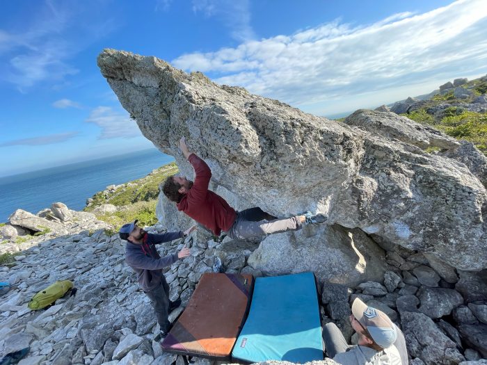 A climber taking on a steep boulder problem and placing a lovely heel hook.